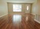 Bright living room featuring hardwood floors, large window, and a welcoming front door at 6301 Baldwyn Ave, New Port Richey, FL 34653