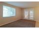Bright living room with neutral walls, carpet, and glass doors to the exterior at 6301 Baldwyn Ave, New Port Richey, FL 34653