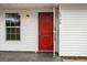 Inviting entryway featuring a vibrant red door, stylish house numbers, and a convenient light fixture at 6358 Dakota Dr, Brooksville, FL 34602