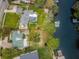 Aerial view of a waterfront home with a pool, boat dock and lush backyard at 646 Riverside Dr, Tarpon Springs, FL 34689