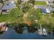 Aerial view of a canal-front property with private dock, lush trees and surrounding neighborhood at 646 Riverside Dr, Tarpon Springs, FL 34689