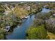 Scenic aerial view of a waterfront community with lush landscaping and private boat docks along a tranquil canal at 646 Riverside Dr, Tarpon Springs, FL 34689