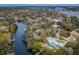 Expansive aerial view of a waterfront neighborhood showcasing multiple homes with pools, boat docks, and river access at 646 Riverside Dr, Tarpon Springs, FL 34689