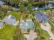 Aerial view of the property showcasing lush landscaping, a canal, and surrounding homes in a residential neighborhood at 646 Riverside Dr, Tarpon Springs, FL 34689