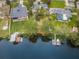 Aerial view of waterfront homes showcasing lush green lawns, a boat dock, and river access at 646 Riverside Dr, Tarpon Springs, FL 34689