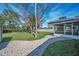 Backyard featuring a shed, landscaping, hardscaped path, trees, green grass and the home at 646 Riverside Dr, Tarpon Springs, FL 34689