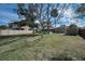 Expansive backyard showcasing green grass, mature trees providing shade, and a screened-in porch at 646 Riverside Dr, Tarpon Springs, FL 34689
