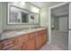 Bathroom with double sink vanity, granite countertop, and doorway to another room at 646 Riverside Dr, Tarpon Springs, FL 34689