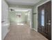 Inviting foyer with neutral tile flooring, leading to a spacious living area and a decorative dark wood door at 646 Riverside Dr, Tarpon Springs, FL 34689