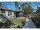 Charming home entrance featuring a stone walkway, green lawn, and a welcoming front door with a wreath at 646 Riverside Dr, Tarpon Springs, FL 34689