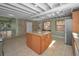 Bright kitchen featuring an island with breakfast bar, tiled flooring, and stainless steel refrigerator at 646 Riverside Dr, Tarpon Springs, FL 34689