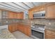 Kitchen featuring stainless steel oven and microwave, granite countertops, and light wood cabinetry at 646 Riverside Dr, Tarpon Springs, FL 34689