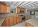 Kitchen featuring granite counters, stainless appliances, and wood cabinets with a view to other rooms at 646 Riverside Dr, Tarpon Springs, FL 34689