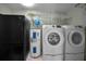Functional laundry area with washer, dryer, refrigerator, and water heater, offering convenience and storage at 646 Riverside Dr, Tarpon Springs, FL 34689