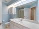 Bathroom with blue walls featuring vanity, sink, toilet, and glass door shower at 6741 Northlake Dr, Zephyrhills, FL 33542
