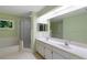 Bright bathroom featuring double sinks, full-sized mirror, shower, and tub at 6741 Northlake Dr, Zephyrhills, FL 33542