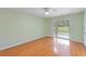 Bright bedroom with wood floors, ceiling fan, and sliding glass doors with view of lawn at 6741 Northlake Dr, Zephyrhills, FL 33542