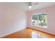Cozy bedroom with light pink walls, wood floors, and beautiful natural light at 6741 Northlake Dr, Zephyrhills, FL 33542