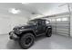 Clean, spacious garage with a black Jeep Wrangler inside at 6741 Northlake Dr, Zephyrhills, FL 33542