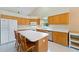 Bright eat-in kitchen with a large island, white counters, oak cabinets, and stainless steel appliances and tile floors at 6741 Northlake Dr, Zephyrhills, FL 33542