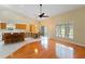 Eat-in kitchen boasts an island with bar seating, a dining nook, and hardwood flooring flowing into the tile kitchen at 6741 Northlake Dr, Zephyrhills, FL 33542
