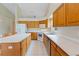 Well-lit kitchen with tile flooring, island with barstools, oak cabinets and an adjacent eating area at 6741 Northlake Dr, Zephyrhills, FL 33542