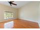 Bright living room boasts wood floors, neutral walls, and a ceiling fan with a large window allowing ample natural light at 6741 Northlake Dr, Zephyrhills, FL 33542