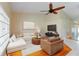Living room with hardwood floors, ceiling fan, and neutral tones, featuring a sectional sofa and adjacent dining area at 6741 Northlake Dr, Zephyrhills, FL 33542