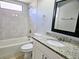 Bathroom with a granite vanity top, shower-tub, and neutral colors offering a modern feel at 7104 Hummingbird Ln, New Port Richey, FL 34655
