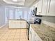Modern kitchen with granite countertops, white cabinets, and stainless steel appliances at 7104 Hummingbird Ln, New Port Richey, FL 34655