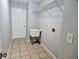 The laundry room includes tiled floor, shelving, utility sink, and washer-dryer hookups for convenience at 7104 Hummingbird Ln, New Port Richey, FL 34655