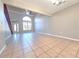 Spacious living room with tiled floors, ceiling fan and large arched window at 7104 Hummingbird Ln, New Port Richey, FL 34655