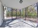 A spacious screened patio with grey tiled floors and natural views at 7104 Hummingbird Ln, New Port Richey, FL 34655