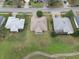 Aerial view shows well-kept lawns, mature landscaping and screened in patios of three residential homes at 7292 Sherman Hills Blvd, Brooksville, FL 34602