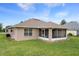 Rear exterior view of the home showcasing the screened lanai, siding, and a lush, green lawn at 7292 Sherman Hills Blvd, Brooksville, FL 34602