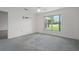 Bedroom with carpet flooring and a large window overlooking a well-maintained lawn at 7292 Sherman Hills Blvd, Brooksville, FL 34602