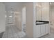 Hallway view of a bathroom with white cabinets, a doorway leading to a bedroom, and the front door at 7292 Sherman Hills Blvd, Brooksville, FL 34602