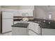 Well-lit kitchen featuring white appliances, dark countertops and a functional layout at 7292 Sherman Hills Blvd, Brooksville, FL 34602