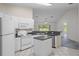 Open kitchen with white cabinets, appliances and a breakfast bar overlooking the adjacent living area at 7292 Sherman Hills Blvd, Brooksville, FL 34602