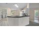 Bright kitchen featuring a breakfast bar with black countertops, white appliances, and laundry area access at 7292 Sherman Hills Blvd, Brooksville, FL 34602