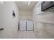 Bright laundry room features tile floors, storage shelves, and a full-size washer and dryer set for convenience at 7292 Sherman Hills Blvd, Brooksville, FL 34602