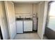 Bright laundry room featuring a washer, dryer, and a water heater, ensuring convenience and efficiency for household chores at 7523 Greystone Dr # 35, Hudson, FL 34667