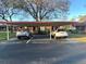 Assigned resident parking spaces under a carport with mature trees nearby at 7523 Greystone Dr # 35, Hudson, FL 34667
