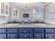 Bathroom featuring double vanity with undermount sinks and dark blue cabinets at 7928 Fashion Loop, New Port Richey, FL 34654