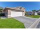 This is the side view of a home with a well maintained green lawn with a long driveway at 7928 Fashion Loop, New Port Richey, FL 34654