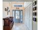 Welcoming foyer featuring tile floors, a bench, a closet, and a stylish glass-paneled front door with transom window at 8032 Spring Hill Dr, Spring Hill, FL 34606