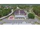 Aerial view of tennis and pickle ball courts with parking and a cabana surrounded by a green space at 8157 Hidden Hills Dr, Spring Hill, FL 34606