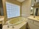 Bathroom with a jetted tub, tile surround, and neutral color palette at 8157 Hidden Hills Dr, Spring Hill, FL 34606