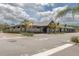Low angled view of a one story light grey building with palm trees and parking spaces in front of the building at 8157 Hidden Hills Dr, Spring Hill, FL 34606