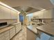 Well-lit kitchen with tile flooring, white cabinets, and modern appliances at 8157 Hidden Hills Dr, Spring Hill, FL 34606